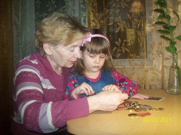 Дочь Людмила и правнучка Анастасия рассматривают награды прадедушки