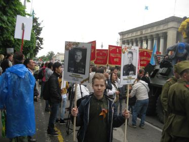 Правнук Акиньшин Фёдор несет пртреты дедов на Параде Победы в Бессмертном полку в городе Алматы