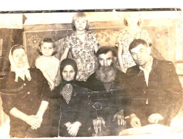на переднем плане слева направо: Мария  - невестка , Прасковья Петровна , сам Кузьма Иванович, его сын - Иван Кузьмич;   на заднем плане слева направо : внучки Кузьмы Ивановича - Галя,  Валя и Полина.
