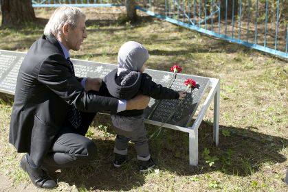 Внук и праправнук возлагают цвету на могилу cвоего героя Олешня Григория Павловича