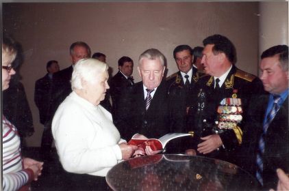Глава города Валерий Шувалов  торжественно вручает книгу Кузовкина жене Вилкова А.Я..
