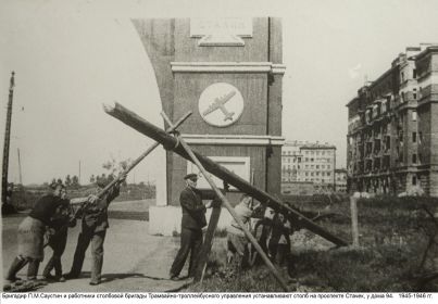 Бригадир П.М.Саустин и работники столбовой бригады устанавливают столб на проспекте Стачек, 94. 1945-1946 гг.