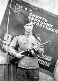 Иван Дмитриевич Бородулин на фоне флага своего полка с ППШ в руках – фото сделано сразу после взятия Берлина