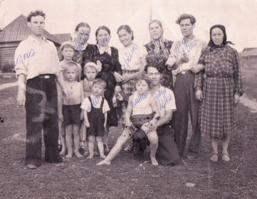 Иван Александрович (слева) с сыном Владимиром (на переднем плане в шортах-комбинезоне), женой Евдокией (в чёрном платье) и роднёй жены, 1960 г