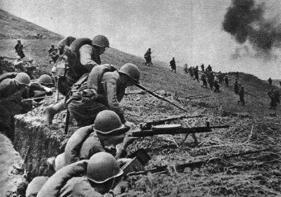 Фотография сделанная военным корреспондентом во время атаки в данном бою. Белов Константин Михайлович ведёт огонь из пулемёта.