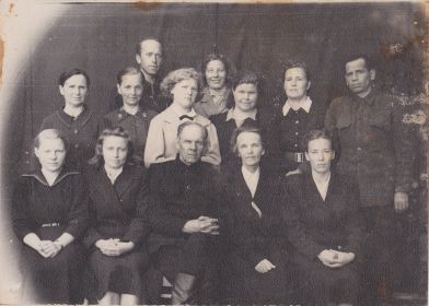 Сидит в первом ряду Дружинин М.А., справа от него жена Мария Михайловна с учителями Трофимовской школы