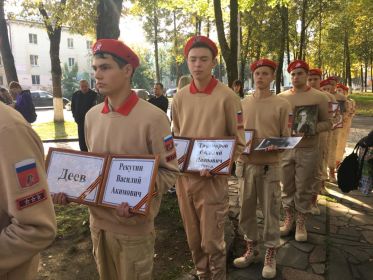 В руках мальчишек  белеют  портреты и таблички с именами и фамилиями бойцов Красной Армии, которых удалось найти и опознать.