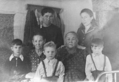 справа сидит мама солдата, Аграфена Фёдоровна, слева его тётя, Александра Максимовна; стоят брат Александр и сестра Клавдия, дети: племянники и сосед; пос. Верхний Ципикан, 1957 год