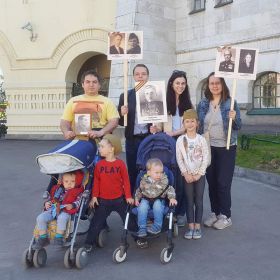 Внуки и правнуки на шествии Бессмертного полка с портретами героев семьи.