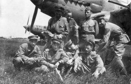 989 шап. Младший лейтенант, летчик Ярмухамедов Сунгат Салахович (слева) с сослуживцами на фоне штурмовиков.