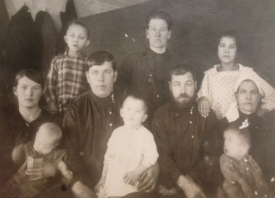 Сидят слева: дед с  сыном Геннадием и жена с дочерью, сидят справа: отец деда Иван Еремеевич, мать и младший брат деда Павел. СтоЯт справа налево: сестра Анна и брат Егор. Мальчик  - чужой