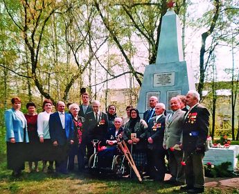 Ветераны войны c жителями пос. Варские у памятника  погибшим в Великой Отечественной войне 1941–1945 гг. На переднем плане - сидит - Нина Михайловна Зыбцева. 2002 г.