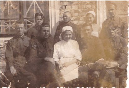 Григорий Клочков в лазарете с группой военных и с медсестрами (крайний слева)