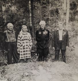 Евдокия Романовна возле партизанской землянки с боевыми товарищами