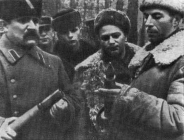А.Ф. Федоров, А.А. Лукин и Д.Н. Медведев рассматривают новый тип трофейного снаряда. Ноябрь 1943 г.