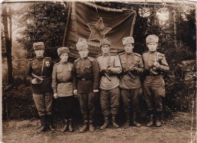 Фотография под развернутым красным знаменем с однополчанами, 1944 год